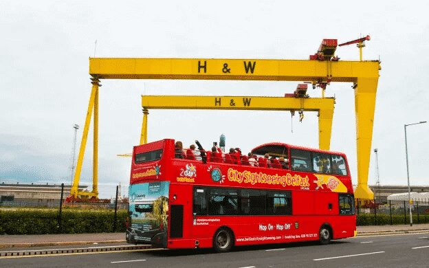 belfast city sightseeing bus in front of harland and wolff cranes