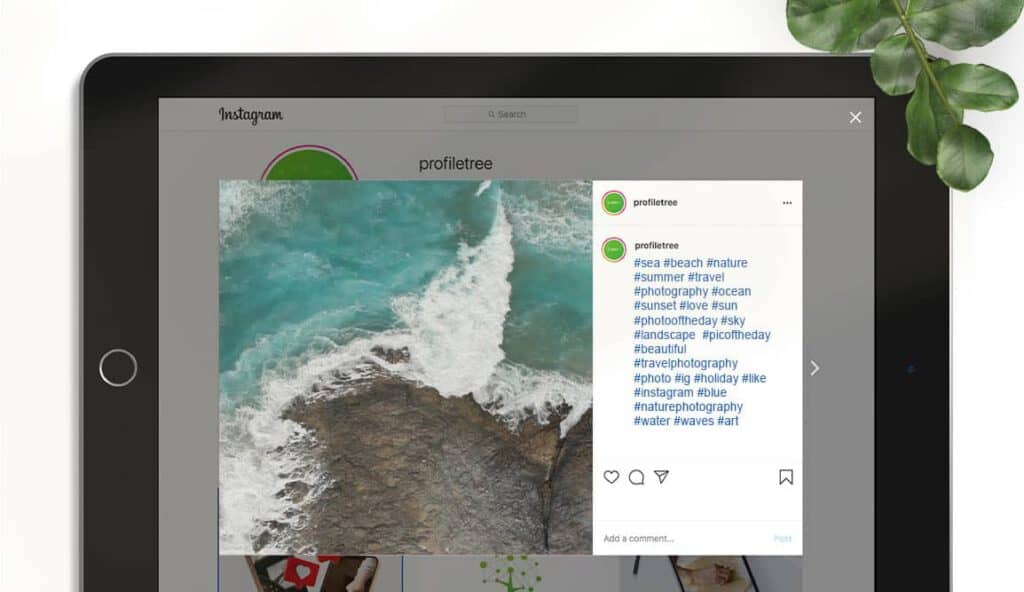 Flat lay of a tablet with a ProfileTree Instagram post of the sea on left-hand side. On right-hand side, a list of hashtags.Instagram search and explore