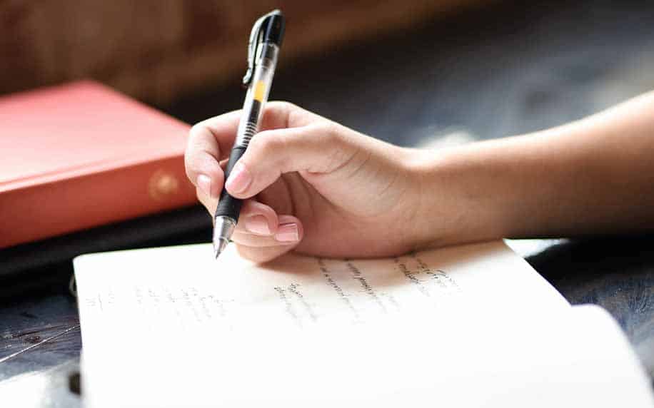 woman writing her introduction notes in a book