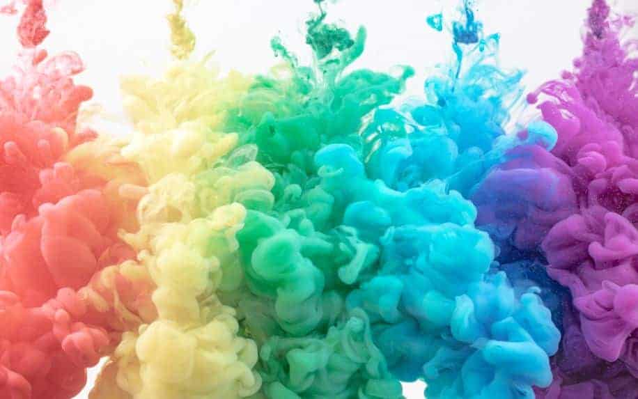 A photo of different coloured chalk dust thrown into water