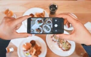 A person taking a photo of their food on an iPhone
