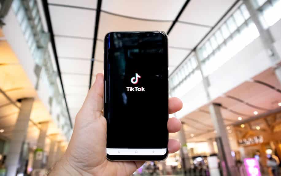 A man using TikTok on an Android in a shopping mall