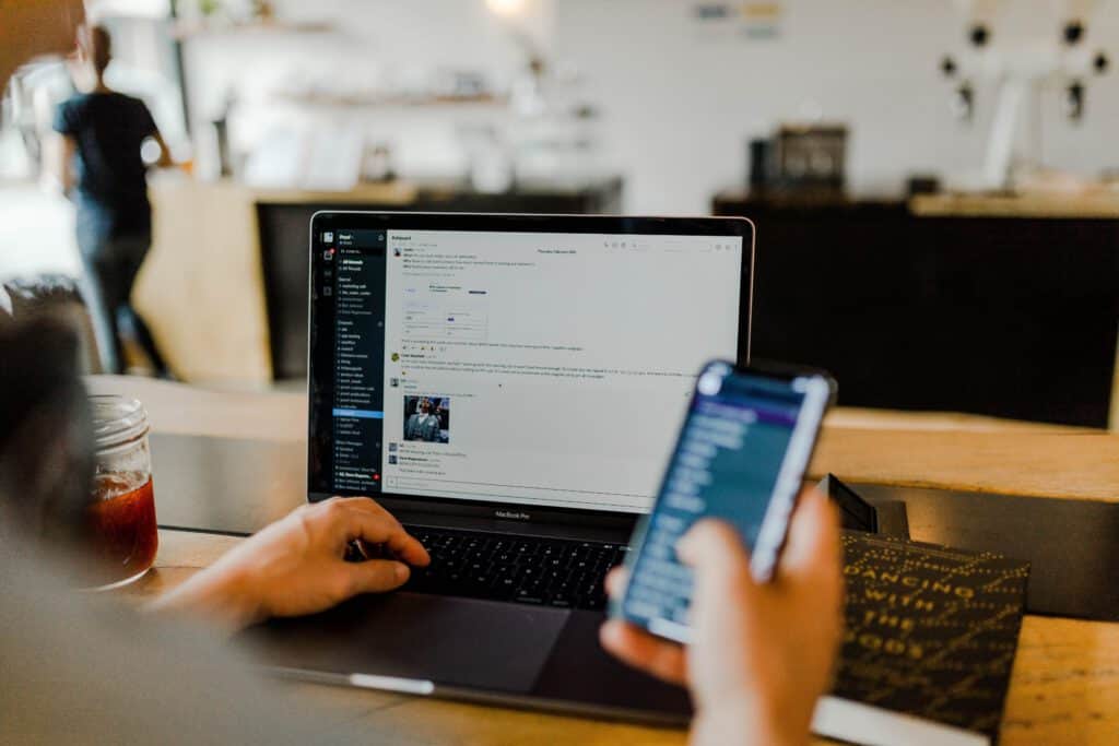 how to become a product manager - man holding phone working on laptop