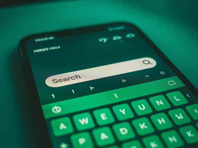 A smartphone search bar representing the common questions UK businesses search when learning about Instagram ads costs and setup.