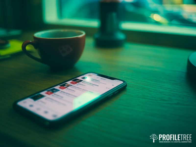 A smartphone displaying a social media feed on a desk, representing the platforms where social media hate speech most commonly occurs