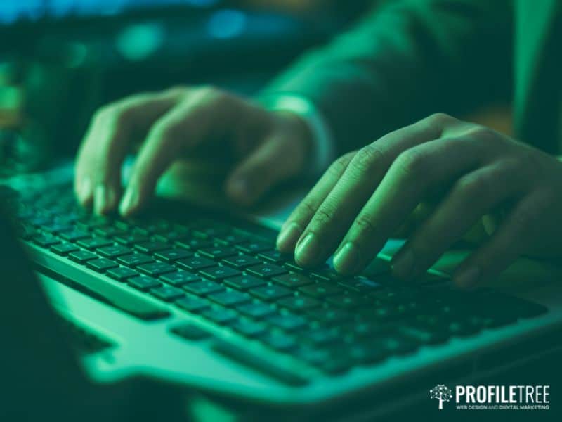 Hands typing on a keyboard, representing the anonymous creation and spread of social media hate speech online