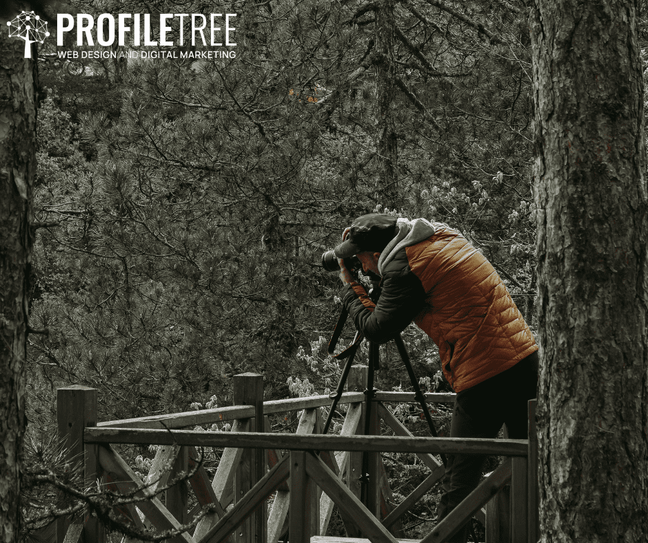 Vlogging Accessories - Man behind a camera placed on a tripod in the middle of the woods